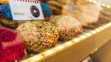 Krakow 'daki bir fırının vitrininde çok renkli şekerleme tozuyla geleneksel Polonya çörekleri, seçici odaklı