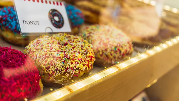 Krakow 'daki bir fırının vitrininde çok renkli şekerleme tozuyla geleneksel Polonya çörekleri, seçici odaklı