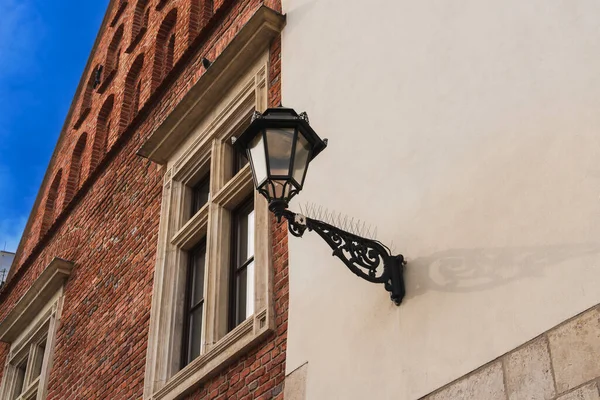 Krakow 'da eski bir evin duvarında klasik sokak lambası var.
