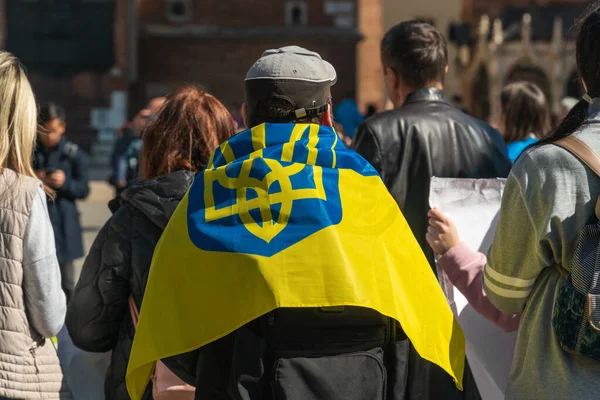 Ukrayna bayrağı, Rus ordusunun Ukrayna 'yı işgaline karşı bir Avrupa şehrinin caddesinde bir grup protestocunun omuzlarında.