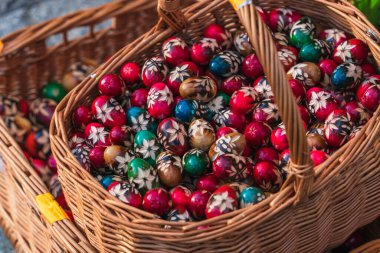 Polonya, Krakow 'daki Paskalya pazarının tezgahında bir sepet tahta Paskalya yumurtası. Geleneksel Paskalya sembolleri. Seçici odak
