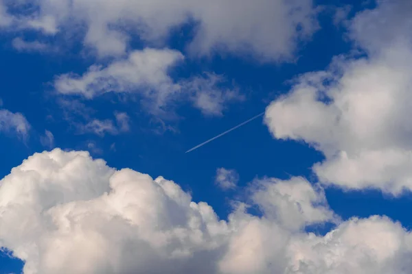 Vit Strimma Ett Jetplan Den Blå Himlen Mellan Vita Cumulus — Stockfoto
