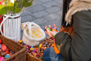 Polonya 'nın Krakow kentindeki geleneksel Paskalya pazarında Paskalya hediyesini seçen bir kadının ellerinde parlak renkli Paskalya yumurtaları.