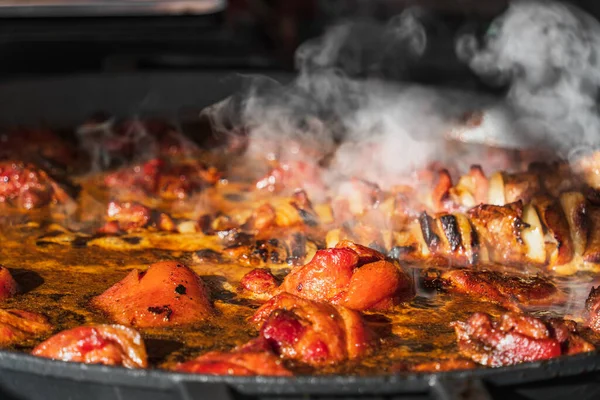 クラクフのオープンエアイースターフードフェスティバルでは ストリートレストランで大きなフライパンに豚のナックルと串焼きを熱します 伝統的なポーランド料理 — ストック写真
