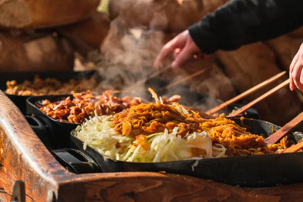 大きな鍋の野菜 屋外市場での熱い料理に焦点を当てています 伝統的なポーランド料理の上に白い蒸気とシェフの手クラクフ — ストック写真