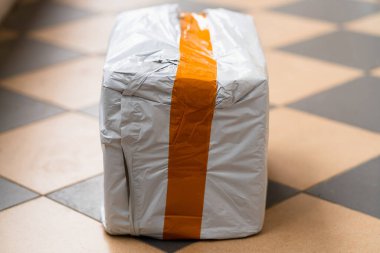 Gerçek posta paketi. Sipariş edilmiş turuncu çizgili beyaz kutu.