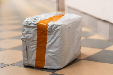 Gerçek posta paketi. Sipariş edilmiş turuncu çizgili beyaz kutu.