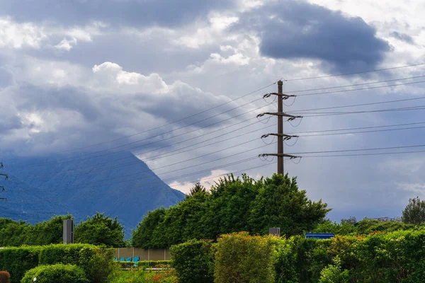 在瑞士阿尔卑斯山山林脚下的高电线杆 在多云的天气里 云彩覆盖着山顶 — 图库照片