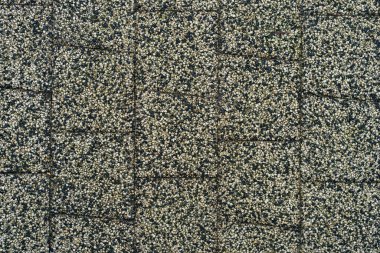 Arka plan için yağmurdan sonra kaldırım levhalarının ıslak kaba yüzeyi, tek tip doğal yol arka planı