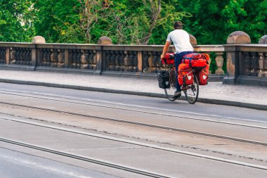 Beyaz tişörtlü bir adam Prag, Çek Cumhuriyeti 'nde tramvay raylarının yanındaki caddede sürüş yapıyor. Avrupa şehirlerinde bisiklet, sağlıklı yaşam tarzı, çevre dostu ulaşım