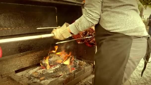 一位街头厨师从布拉格街上的一棵燃烧的树上烤着的金属吐司上取下了一大块热猪肉 捷克传统烹饪 — 图库视频影像