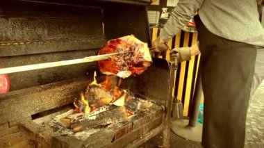 Bir sokak şefi, Prag 'da bir caddede yanan bir ağacın alevleri üzerinde yavaşça dönen metal bir tükürükte büyük bir domuz eti kızartıyor. Geleneksel Çek mutfağı