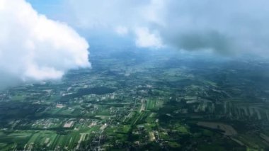 Uçağın penceresinden dışarı bak, kalın beyaz bulutların altında yer, uçak büyük bir buluta girer. Taşıma ve seyahat, bulutlardan yeryüzüne bakış.