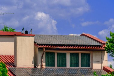 Polonya 'nın Krakow kentindeki özel bir evin çatısındaki güneş panelleri modern ve sürdürülebilir bir şekilde güneşten yeşil enerji topluyor. Polonya evlerinde yeni teknoloji yeşil doğayla çevrili.