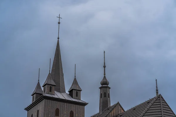 Black wood catholic christian temple on a cloudy day, dramatic rainy sky, sacrament of faith, christian temple geometry, catholic religion