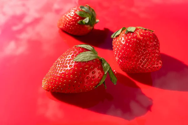 Three Red Ripe Strawberries Red Surface Clouds Reflection Red Background — Fotografia de Stock