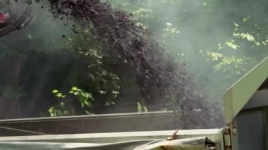 Replacing old asphalt when repairing the road surface. A road car removes the old asphalt and puts it in the back of a truck. Road repair and reconstruction in Europe