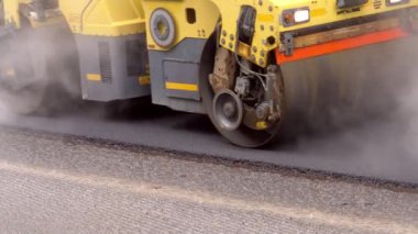Replacing old asphalt when repairing the road surface. Road rollers level new hot asphalt. Repair and reconstruction of pavement in Europe. Close-up