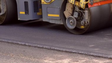 Replacing old asphalt when repairing the road surface. Asphalt paver lays bitumen and new hot asphalt. Repair and reconstruction of pavement in Europe. Close-up of a hot asphalt bunker