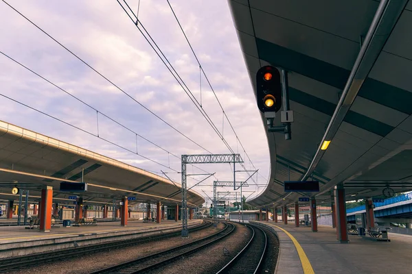 Railway traffic light, red and yellow light stop, passenger train station, platform, railway background, early morning, cloudy sky over the railway, rail traffic, close-up