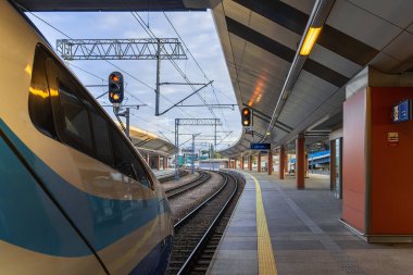 High-speed train on the railway platform in the early morning, passengers are waiting to board the train cars, railway background, rail travel, railway in Krakow. Copy space