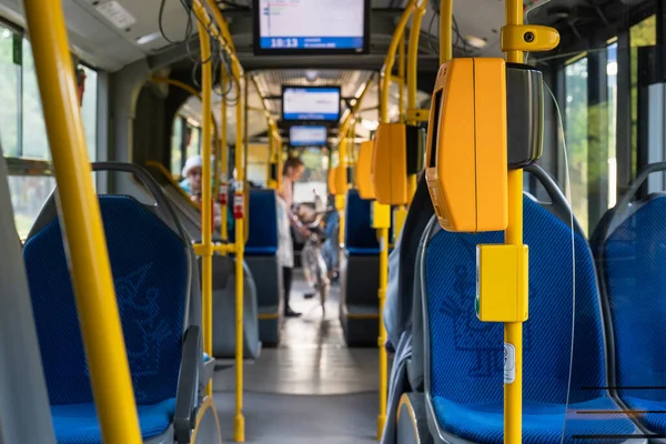 Modern bus interior with passengers and bicycle. Passengers in the city bus in the evening in Krakow. Modern public transport in Europe. Travel and tourism concept. Comfortable travel.