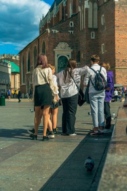 Bir grup ortaokul öğrencisi, güneşli bir sonbahar gününde eski bir Avrupa şehrinin merkezinde okuldan sonra, Eylül 'de okula, Polonya' nın Krakow kentindeki okul çocuklarına yürüyorlar. Dikey Yönlendirme