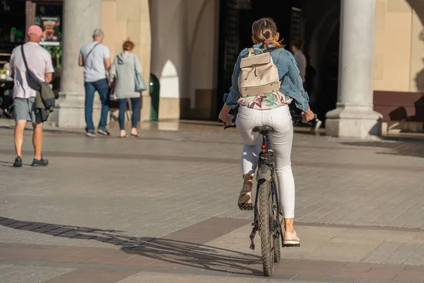 Rowerzystka Białych Dżinsach Plecakiem Plecach Jeździ Rowerem Słoneczny Dzień Placu — Zdjęcie stockowe