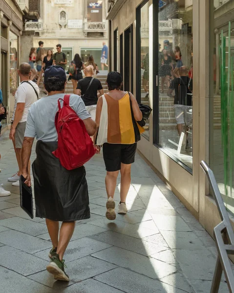 Bir yaz sabahı Venedik 'in eski dar sokaklarında sırt çantalı ve çantalı turistler ve gezginler, tarihi yerlere seyahat, İtalya' nın simgeleri, sokak fotoğrafçılığı