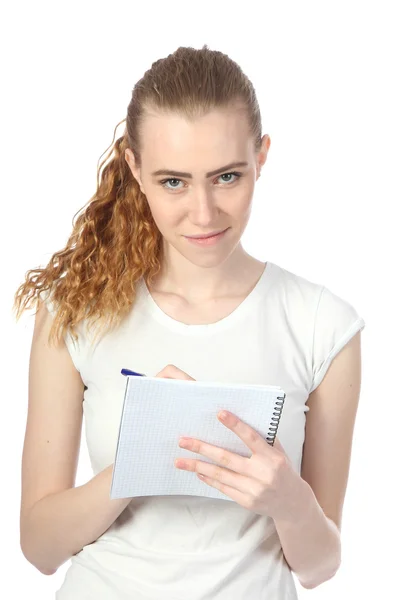 The young woman writes to a writing-book — Stock Photo, Image