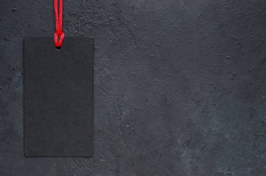 Siyah etiket sallanıyor. Koyu beton arka plan. Kara Cuma 'da tatil satışları fikri. Boşluğu kopyala
