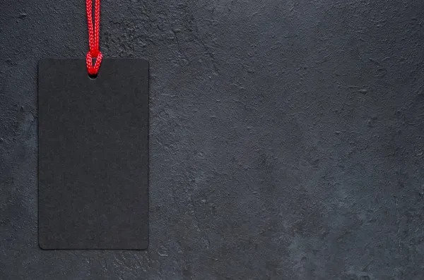 Siyah etiket sallanıyor. Koyu beton arka plan. Kara Cuma 'da tatil satışları fikri. Boşluğu kopyala