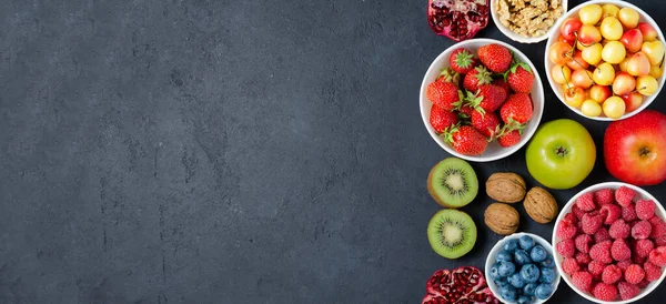 Food with a high content of antioxidants: berries, nuts, fruits. Black concrete background. Copy space