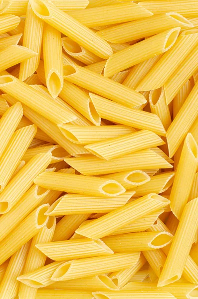 Rohe Penne-Nudeln. Lebensmittel-Hintergrund. Eine Zutat für die traditionelle italienische Küche. Nahaufnahme — Stockfoto