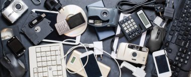 Karanlık bir arka planda eski elektronik cihazlar. Elektronik atıkların geri dönüşümü ve atılması kavramı