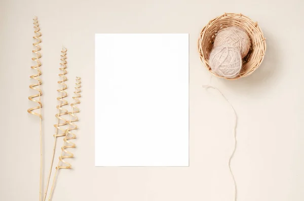 Un cuaderno blanco, hilos en una canasta de mimbre y una rama decorativa de una vid seca. Fondo beige. Copiar espacio. — Foto de Stock