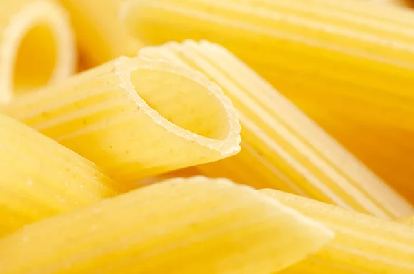 Rohe Penne-Nudeln. Lebensmittel-Hintergrund. Eine Zutat für die traditionelle italienische Küche. Nahaufnahme — Stockfoto