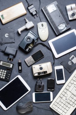 Karanlık bir arka planda eski elektronik cihazlar. Elektronik atıkların geri dönüşümü ve atılması kavramı.