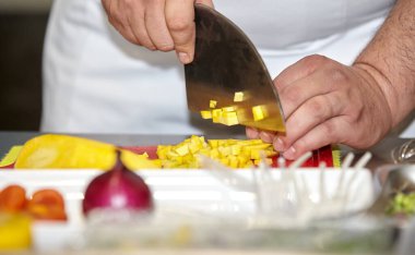 Mutfaktaki şef meyve salatası için taze ananası bıçakla keser. Sağlıklı beslenme ve yaşam tarzı. Erkek elleri yakın.