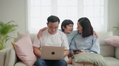 Asyalı bir ailenin oturma odasındaki kanepede dinlenmesi, aile ilişkisi.