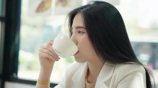Die Schöne Asiatin Sitzt Gemütlich Einem Café Und Nippt Ihrem — Stockvideo