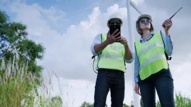 İki mühendis birlikte rüzgar enerjisi projelerini tartışıyorlar ve rüzgar türbini alanında çalışıyorlar, temiz enerji kavramı, yenilenebilir enerji, dünyayı kurtarmak..