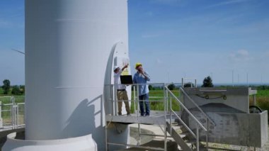 İki mühendis birlikte rüzgar enerjisi projelerini tartışıyorlar ve rüzgar türbini alanında çalışıyorlar, temiz enerji kavramı, yenilenebilir enerji, dünyayı kurtarmak..