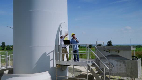 Dwóch Inżynierów Wspólnie Omawia Projekty Energetyki Wiatrowej Pracuje Polu Turbin — Wideo stockowe