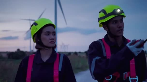 夕暮れ時に2人の安全装置のメンテナンス技術者が風力タービンへの高さを歩いて風力タービンの動作を確認し クリーンエネルギーコンセプト 再生可能エネルギー 世界を救う — ストック動画