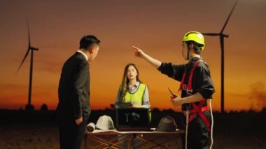 Rüzgâr türbini jeneratörü alanında, bir bakım mühendisi bir rüzgar türbini bakım projesinin sonuçlarını rapor ediyor..