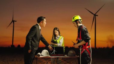 Rüzgâr türbini jeneratörü alanında, bir bakım mühendisi bir rüzgar türbini bakım projesinin sonuçlarını rapor ediyor..