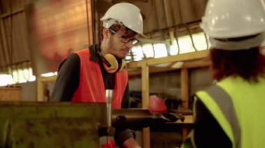 Fabrika mühendisleri ve arkadaşları bir endüstriyel fabrikanın içindeki makineleri inceliyorlar, işyeri güvenliği fikri.
