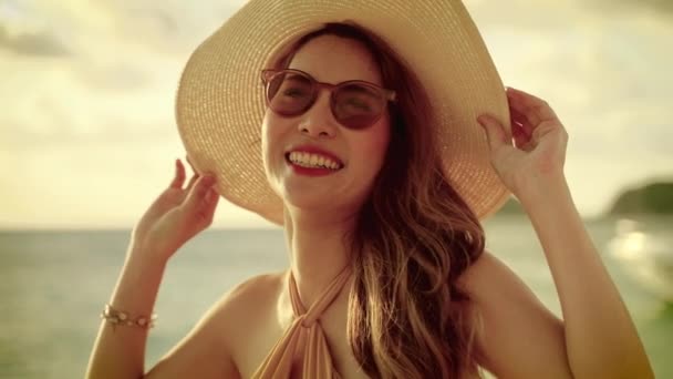 夕方には太陽は日没です 美しいアジアの女の子は ソムブレロを着て 彼女の休暇にビーチを歩いて 自由の概念 — ストック動画