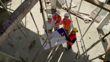 Üst köşe, inşaat mühendisliği ekibi mimar ve ustabaşıyla birlikte Blue Print 'i izliyor ve inşaat alanının inşaatını planlıyor..